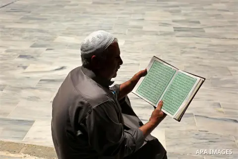 A Palestinian man reads a copy of the Koran, Islam's holiest book, on the first day of fasting in the Muslim holy month of Ramadan, at the al-Omari mosque in Gaza City, on May 27, 2017. Ramadan is sacred to Muslims becau...
