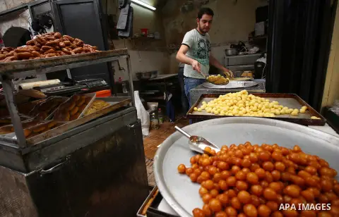 A Palestinian vendor prepares sweets on the Muslim holy fasting month of Ramadan at his shop in the Old City of the West Bank town of Nablus on May 28, 2017. Ramadan is sacred to Muslims because it is during that month t...