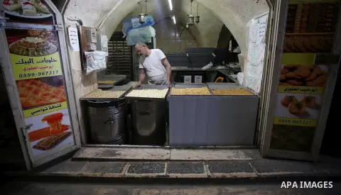 A Palestinian vendor sells traditional pancakes known as ''Qatayef'' on the Muslim holy fasting month of Ramadan at his shop in the Old City of the West Bank town of Nablus on May 28, 2017. Ramadan is sacred to Muslims b...