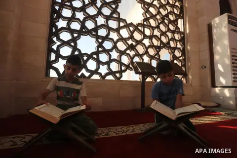 Palestinian boys read a copy of the Koran, Islam's holiest book, on the Muslim holy fasting month of Ramadan at al-Khaldi mosque in Gaza city on May 31, 2017. Ramadan is sacred to Muslims because it is during that month...