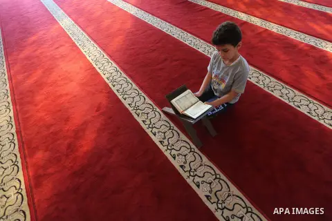 A Palestinian boy reads a copy of the Koran, Islam's holiest book, on the Muslim holy fasting month of Ramadan at al-Khaldi mosque in Gaza city on May 31, 2017. Ramadan is sacred to Muslims because it is during that mont...