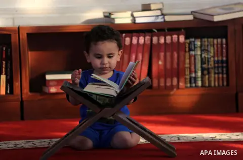 A Palestinian boy reads a copy of the Koran, Islam's holiest book, on the Muslim holy fasting month of Ramadan at al-Khaldi mosque in Gaza city on May 31, 2017. Ramadan is sacred to Muslims because it is during that mont...
