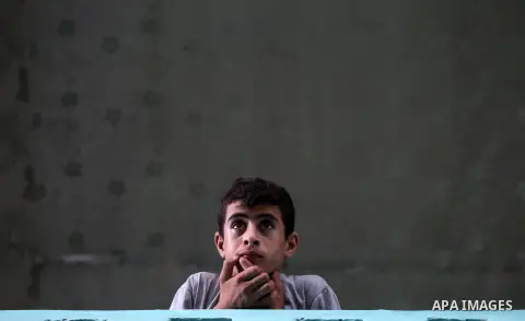 A Palestinian boy looks from balcony during the funeral of a member the Ezzedine al-Qassam Brigades, the military wing of the Palestinian Islamist movement Hamas of Ibrahim Abu Al-Naja, in Rafah southern Gaza Strip June...