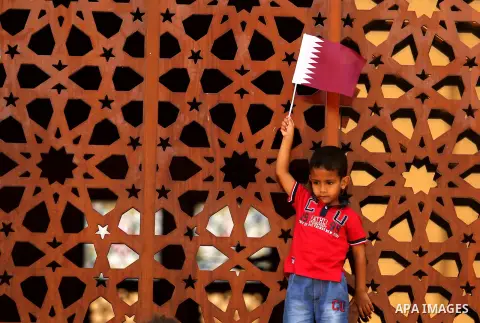 A Palestinian boy holds Qatari flag in a rally in support of Qatar, inside Qatari-funded construction project 'Hamad City', in Khan Younis in the southern Gaza Strip, June 14, 2017. Photo by Ashraf Amra