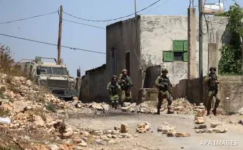 Israeli security forces aim their weapons towards Palestinian protesters during clashes following a demonstration against the expropriation of Palestinian land by Israel in the village of Kfar Qaddum, near Nablus, in the...