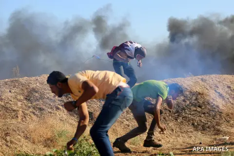 Palestinian protesters take cover during clashes with Israeli security forces following a demonstration against the blockade on the Gaza Strip, near the border fence east of Jabalia refugee camp on June 16, 2017. Photo b...