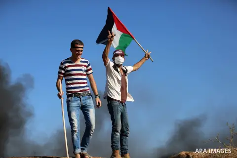 Palestinian protesters take cover during clashes with Israeli security forces following a demonstration against the blockade on the Gaza Strip, near the border fence east of Jabalia refugee camp on June 16, 2017. Photo b...