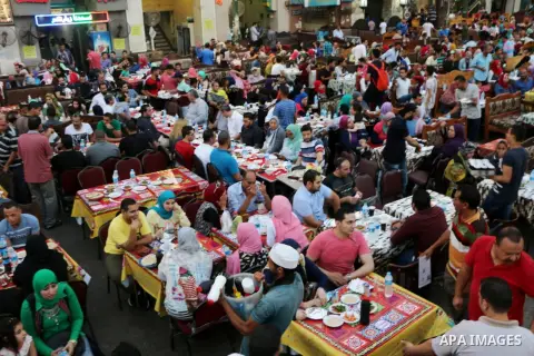 Egyptian muslims take their breakfast during the holy fasting month of Ramadan in front of al-Hussein mosque at Al-Azhar district in old Islamic Cairo, Egypt, on June 17, 2017. Ramadan is sacred to Muslims because it is...