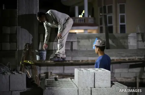 Palestinian labourers work at construction site at night, to avoid the day time heat, on the Muslim holy fasting month of Ramadan in Gaza city on June 17, 2017. Ramadan is sacred to Muslims because it is during that mont...