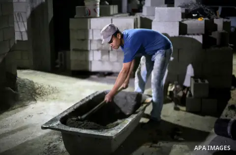 A Palestinian labourer works at construction site at night, to avoid the day time heat, on the Muslim holy fasting month of Ramadan in Gaza city on June 17, 2017. Ramadan is sacred to Muslims because it is during that mo...
