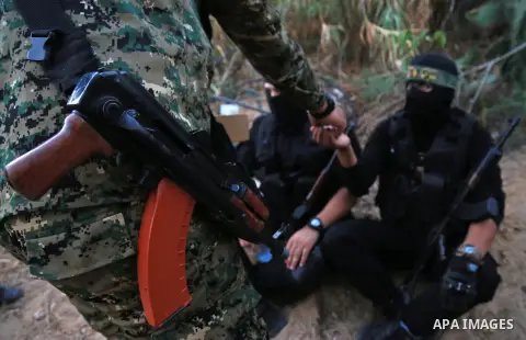 Palestinian militants from the Al-Quds Brigades, the armed wing of the Islamic Jihad movement break their fast as they guard the border between the Gaza Strip and Israel on the Muslim holy fasting month of Ramadan on Jun...