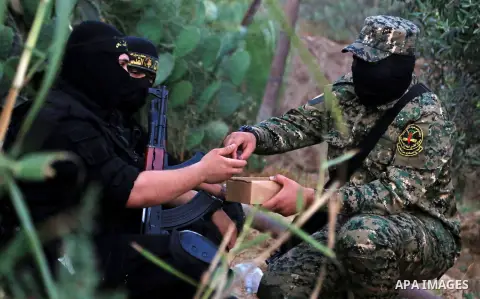 Palestinian militants from the Al-Quds Brigades, the armed wing of the Islamic Jihad movement break their fast as they guard the border between the Gaza Strip and Israel on the Muslim holy fasting month of Ramadan on Jun...