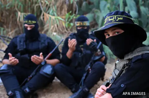 Palestinian militants from the Al-Quds Brigades, the armed wing of the Islamic Jihad movement perform prayer as they guard the border between the Gaza Strip and Israel on the Muslim holy fasting month of Ramadan on June...