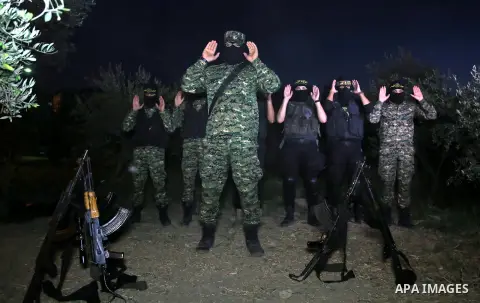 Palestinian militants from the Al-Quds Brigades, the armed wing of the Islamic Jihad movement perform prayer as they guard the border between the Gaza Strip and Israel on the Muslim holy fasting month of Ramadan on June...