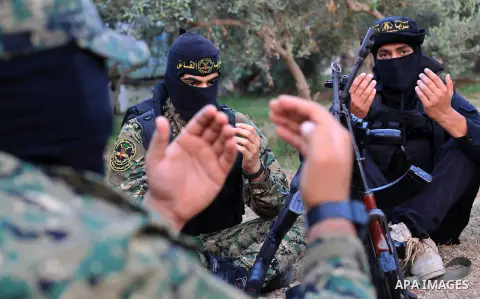 Palestinian militants from the Al-Quds Brigades, the armed wing of the Islamic Jihad movement perform prayer as they guard the border between the Gaza Strip and Israel on the Muslim holy fasting month of Ramadan on June...
