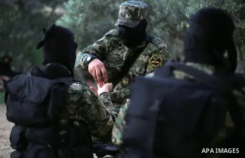 Palestinian militants from the Al-Quds Brigades, the armed wing of the Islamic Jihad movement break their fast as they guard the border between the Gaza Strip and Israel on the Muslim holy fasting month of Ramadan on Jun...