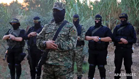 Palestinian militants from the Al-Quds Brigades, the armed wing of the Islamic Jihad movement perform prayer as they guard the border between the Gaza Strip and Israel on the Muslim holy fasting month of Ramadan on June...