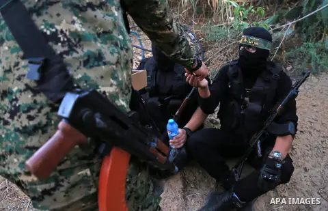 Palestinian militants from the Al-Quds Brigades, the armed wing of the Islamic Jihad movement break their fast as they guard the border between the Gaza Strip and Israel on the Muslim holy fasting month of Ramadan on Jun...