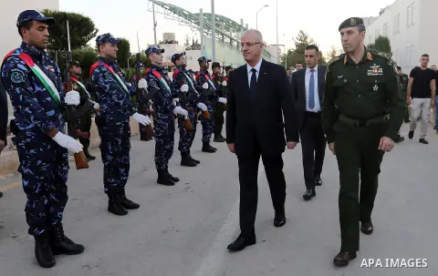 Palestinian Prime Minister Rami Hamdallah reviews the honor guards as he arrives to breakfasting with security forces on the Muslim holy fasting month of Ramadan, in the West Bank city of Jenin on June 18, 2017. Photo by...