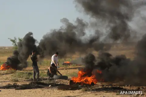 Palestinians react to tear gas fired by Israeli troops during clashes at a protest against reducing power supply to Gaza, near the border with Israel in Khan Younis in the southern Gaza Strip June 20, 2017. Photo by Ashr...