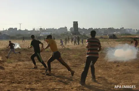 Palestinians react to tear gas fired by Israeli troops during clashes at a protest against reducing power supply to Gaza, near the border with Israel in Khan Younis in the southern Gaza Strip June 20, 2017. Photo by Ashr...