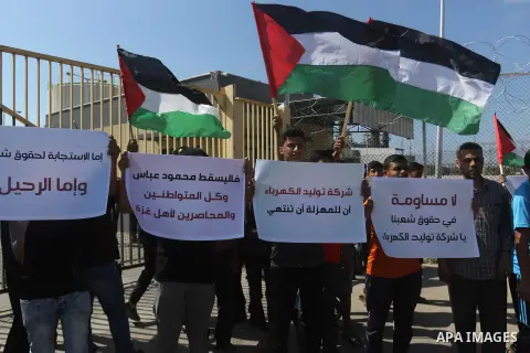 Palestinians hold banners during a protest against the worsening crisis of power outages in front of Gaza's power plant in Nuseirat in the center of Gaza strip, on June 21, 2017. Egypt began to deliver a million litres o...