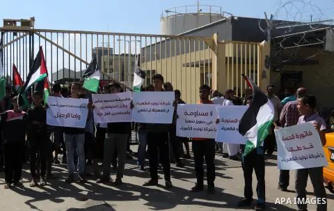 Palestinians hold banners during a protest against the worsening crisis of power outages in front of Gaza's power plant in Nuseirat in the center of Gaza strip, on June 21, 2017. Egypt began to deliver a million litres o...
