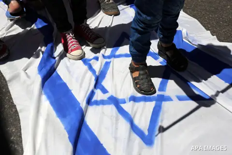 Palestinian children step on the Israeli flag in a protest marking the annual al-Quds Day, or Jerusalem Day, following Friday prayer in Gaza city June 23, 2017. Photo by Ashraf Amra