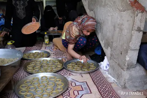 A Palestinian girl makes traditional date-filled cookies with her family in preparation for the Eid al-Fitr holiday at their home in Rafah, in the southern Gaza Strip, on June 23, 2017. Muslims around the world are prepa...