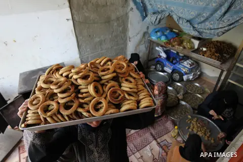 A Palestinian family make traditional date-filled cookies in preparation for the Eid al-Fitr holiday at their home in Rafah, in the southern Gaza Strip, on June 23, 2017. Muslims around the world are preparing to celebra...