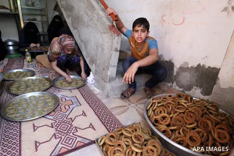 A Palestinian family make traditional date-filled cookies in preparation for the Eid al-Fitr holiday at their home in Rafah, in the southern Gaza Strip, on June 23, 2017. Muslims around the world are preparing to celebra...