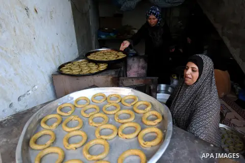A Palestinian family make traditional date-filled cookies in preparation for the Eid al-Fitr holiday at their home in Rafah, in the southern Gaza Strip, on June 23, 2017. Muslims around the world are preparing to celebra...