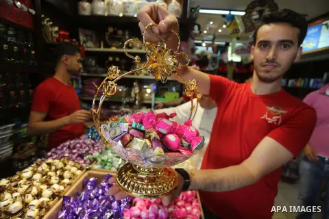 Palestinians sell chocolate at a shop ahead of the Eid al-Fitr holiday, in Gaza city, on JUne 23, 2017. Eid al-Fitr marks the end of Muslim's holy fasting month of Ramadan when faithfuls abstain from eating, drinking, sm...