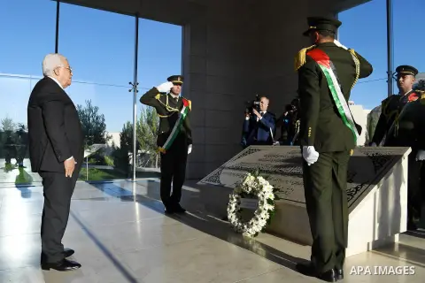 Palestinian President Mahmoud Abbas lays a wreath on the grave of late Palestinian leader Yasser Arafat on the first day of Eid al-Fitr, in the West Bank city of Ramallah on June 25, 2017. Photo by Thaer Ganaim