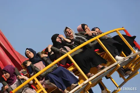 Palestinians take a ride at an amusement park on the third day of Eid al-Fitr holiday which marks the end of the Muslim holy month of Ramadan, in Gaza City on June 27, 2017. Photo by Ashraf Amra