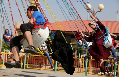 Palestinians take a ride at an amusement park on the third day of Eid al-Fitr holiday which marks the end of the Muslim holy month of Ramadan, in Gaza City on June 27, 2017. Photo by Ashraf Amra