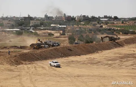 Parliment Palestinian bulldozers clear an area as Hamas begins creating a large buffer zone on the border with Egypt in the southern Gaza strip town of Rafah, on June 29, 2017. The buffer zone is expected to extend for a...