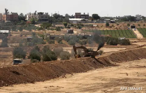 Parliment Palestinian bulldozers clear an area as Hamas begins creating a large buffer zone on the border with Egypt in the southern Gaza strip town of Rafah, on June 29, 2017. The buffer zone is expected to extend for a...