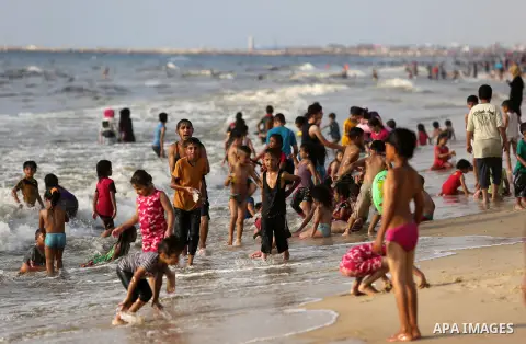 Palestinians enjoy their time at the beach of the Mediterranean sea on the coast of Gaza city, on June 30, 2017. Photo by Ashraf Amra