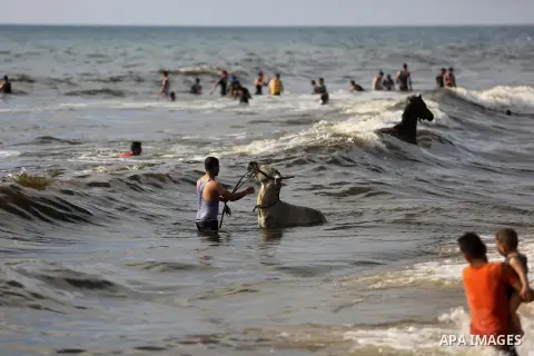 Palestinians enjoy their time at the beach of the Mediterranean sea on the coast of Gaza city, on June 30, 2017. Photo by Ashraf Amra