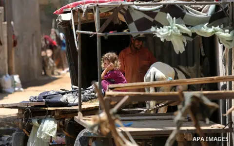 A Palestinian girl stands outside her family house during a heatwave in Beit Lahia in the northern of Gaza Strip, on July 4, 2017. Photo by Ashraf Amra
