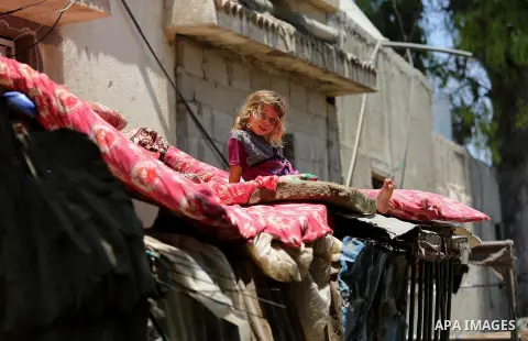 A Palestinian girl stands outside her family house during a heatwave in Beit Lahia in the northern of Gaza Strip, on July 4, 2017. Photo by Ashraf Amra