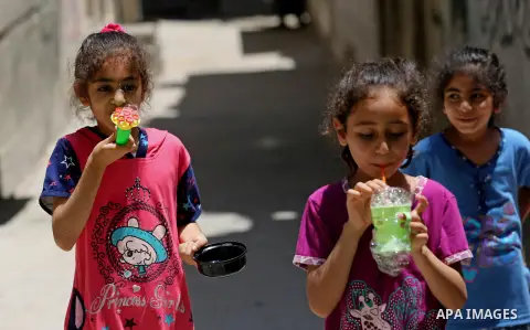 Palestinian children blow bubbles at street during a heatwave in Beit Lahia in the northern of Gaza Strip, on July 4, 2017. Photo by Ashraf Amra