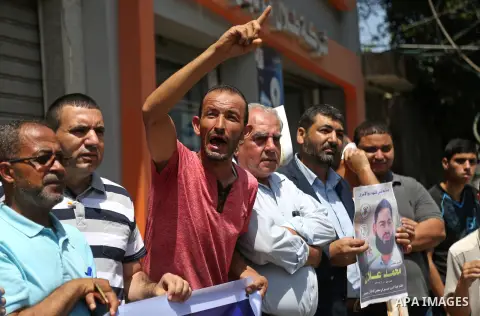 Palestinian supporters of the Islamic Jihad Movement, hold placards during a protest to show solidarity with Palestinian prisoners held in Israeli Jails, in Gaza city, on July 5, 2017. Photo by Ashraf Amra