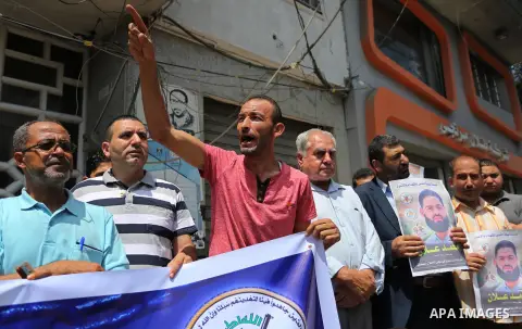 Palestinian supporters of the Islamic Jihad Movement, hold placards during a protest to show solidarity with Palestinian prisoners held in Israeli Jails, in Gaza city, on July 5, 2017. Photo by Ashraf Amra
