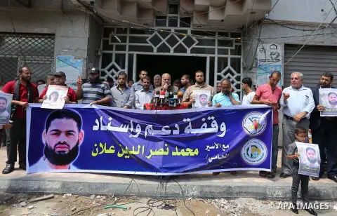 Palestinian supporters of the Islamic Jihad Movement, hold placards during a protest to show solidarity with Palestinian prisoners held in Israeli Jails, in Gaza city, on July 5, 2017. Photo by Ashraf Amra