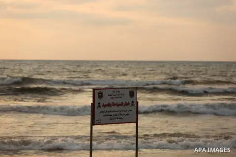A warning sign reading 'dangerous swimming and fishing' is placed near an outlet flowing sewage into the sea in front of the coast of Gaza city, on July 5, 2017. An immediate consequence of the electricity cuts has been...