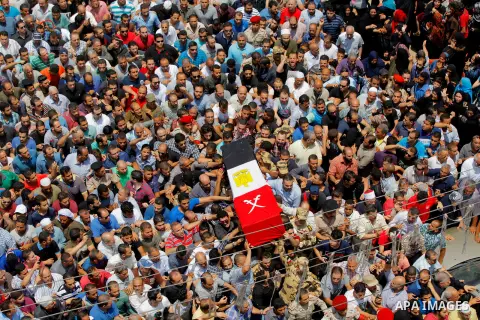 Egyptian relatives and friends carry the coffin of the officer Khaled al-Maghrabi, who was killed during a suicide bomb attack on an army checkpoint in Sinai, during his funeral in his hometown Toukh, Al Qalyubia Governo...