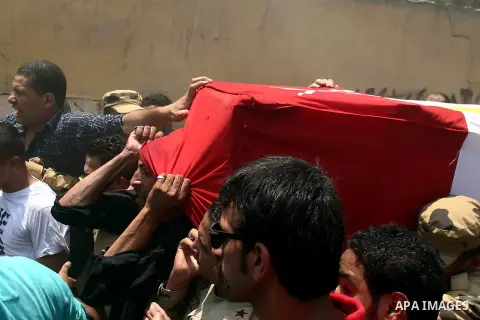 Egyptian relatives and friends carry the coffin of the officer Khaled al-Maghrabi, who was killed during a suicide bomb attack on an army checkpoint in Sinai, during his funeral in his hometown Toukh, Al Qalyubia Governo...