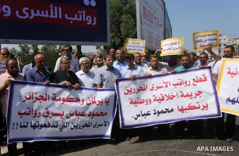 Palestinian released prisoners from Israeli jails hold placards during a protest demanding their salaries in Gaza city on July 9, 2017. Photo by Mohammed Asad
